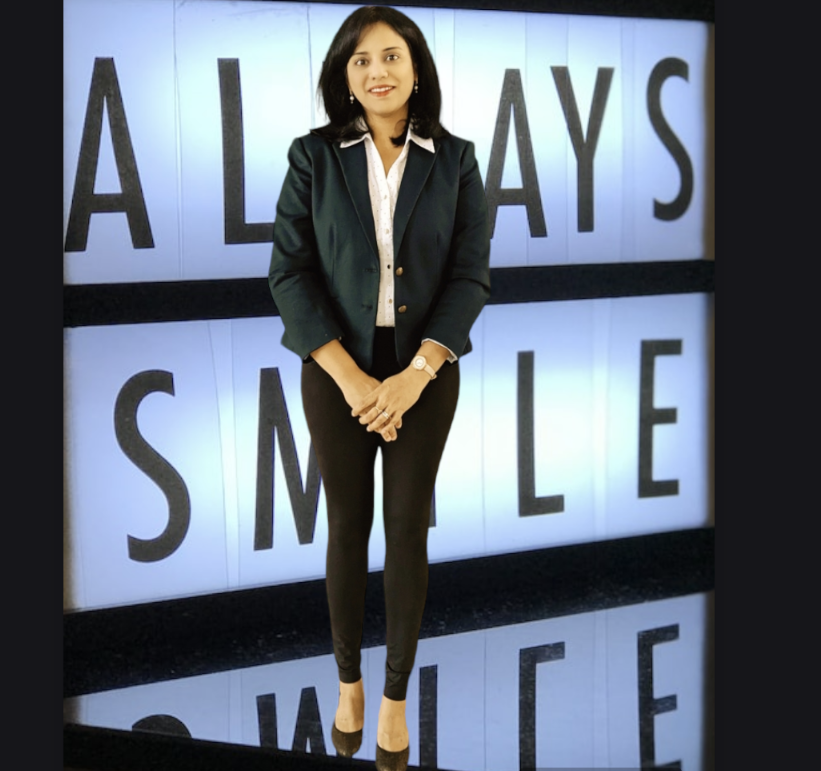 Dr. Prathima Adusumilli standing in front of smile backdrop